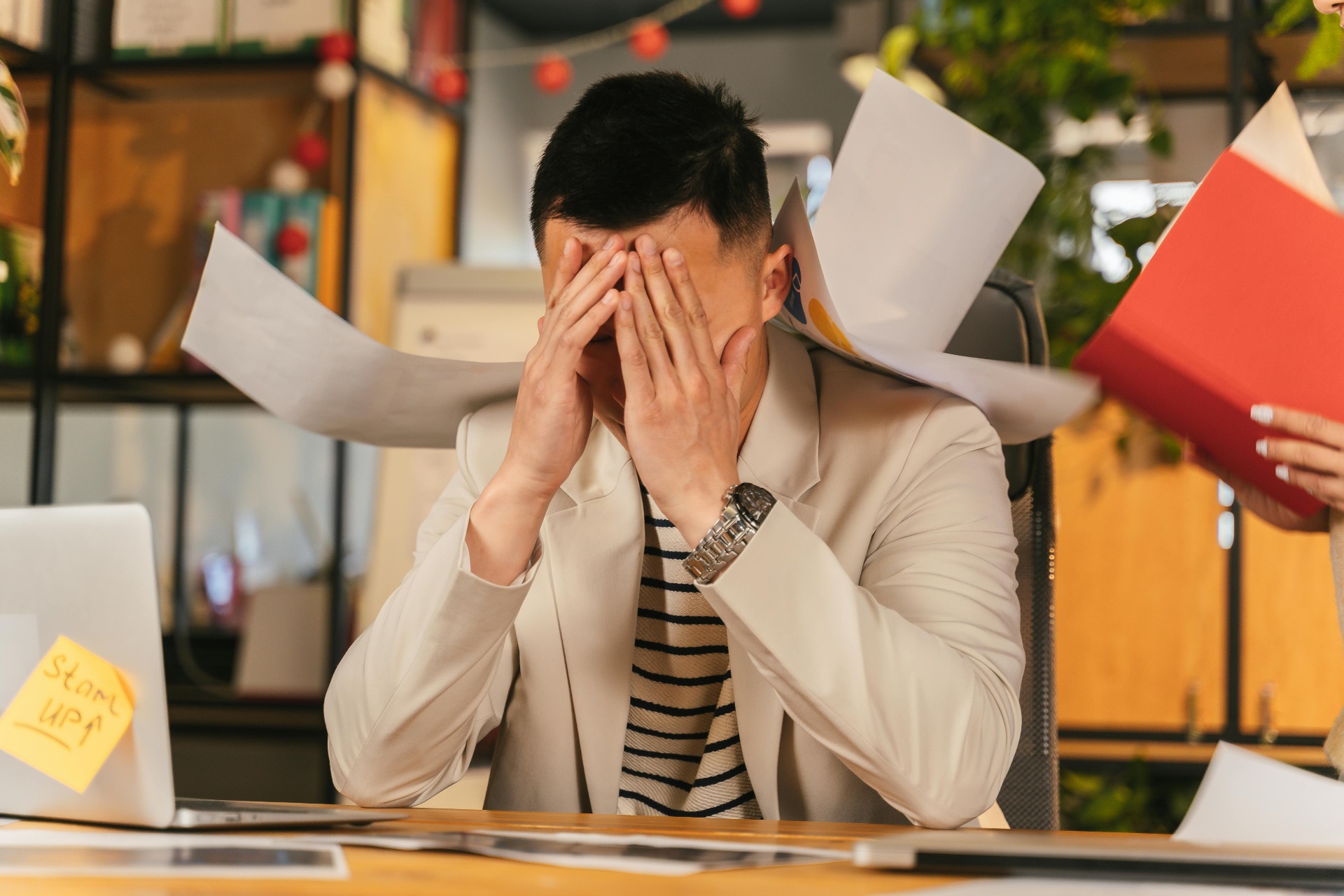 Gestresste werknemer overspoeld met papierwerk na ontslag