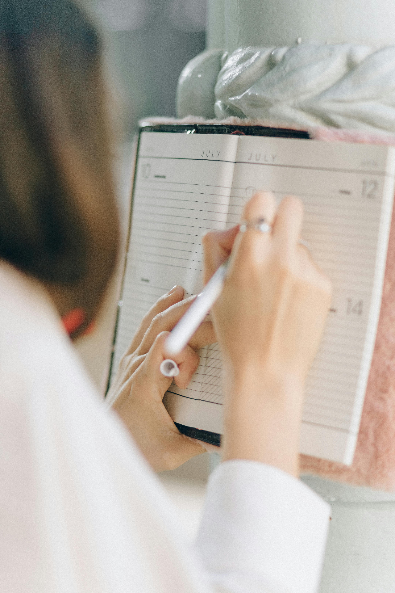 Vrouw schrijft planningsstappen in notitieboekje bij reorganisatie