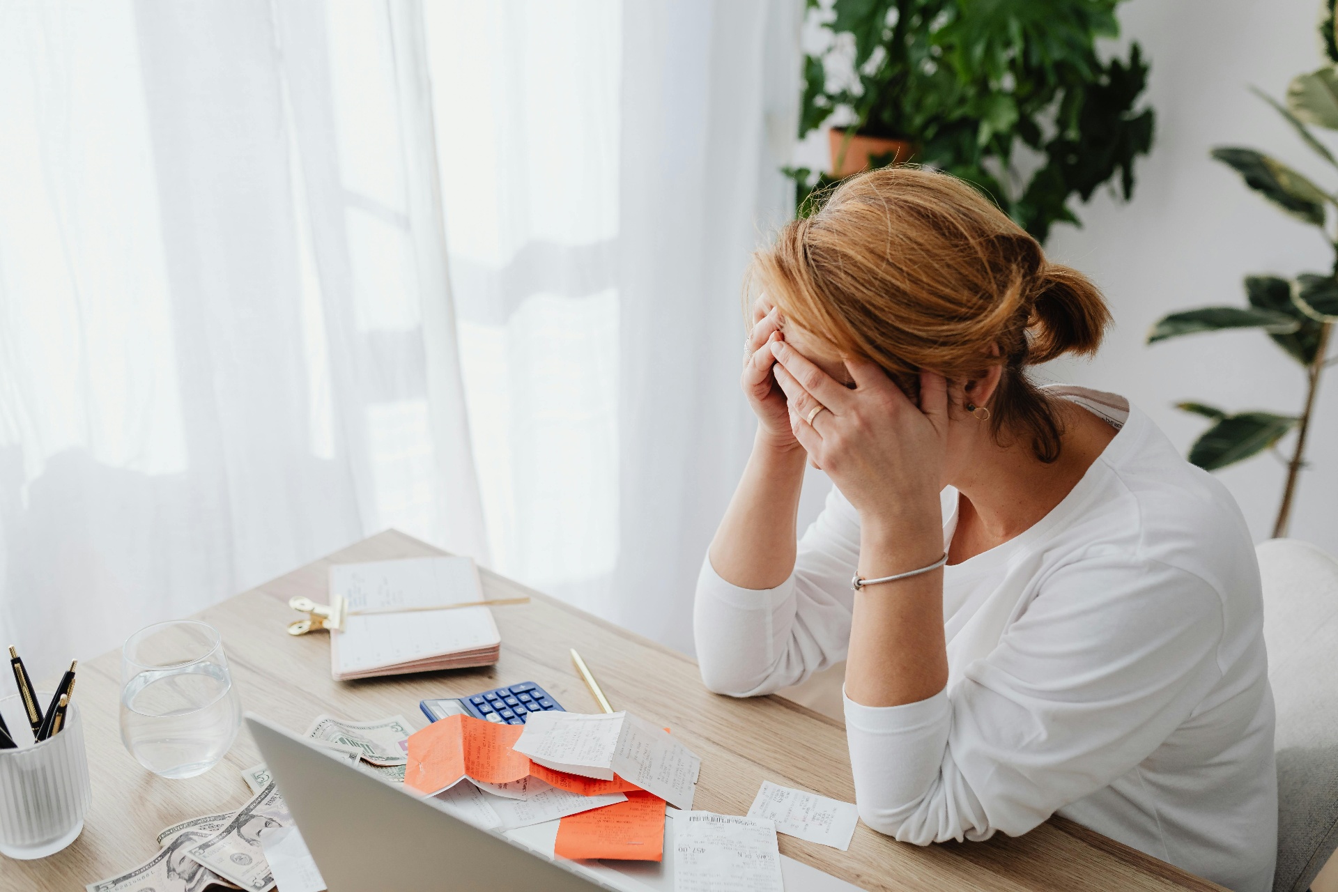 Gefrustreerde vrouw achter bureau met rekeningen - valkuilen bij vaststellingsovereenkomst